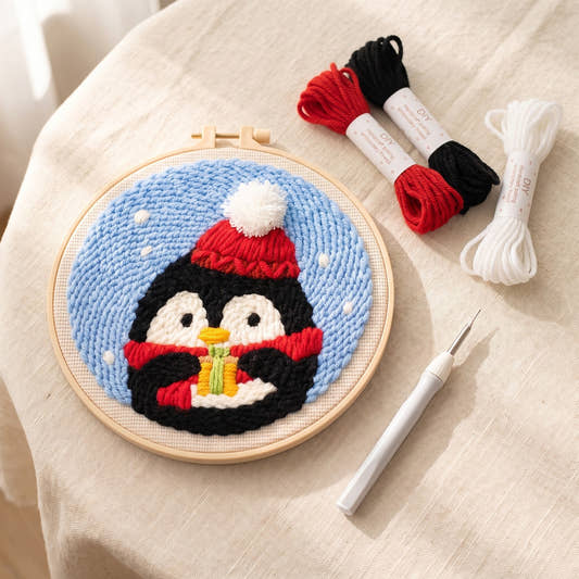 Kit punch needle motif Pingouin au bonnet, vue de dessus avec des écheveaux (photo d'ambiance)
