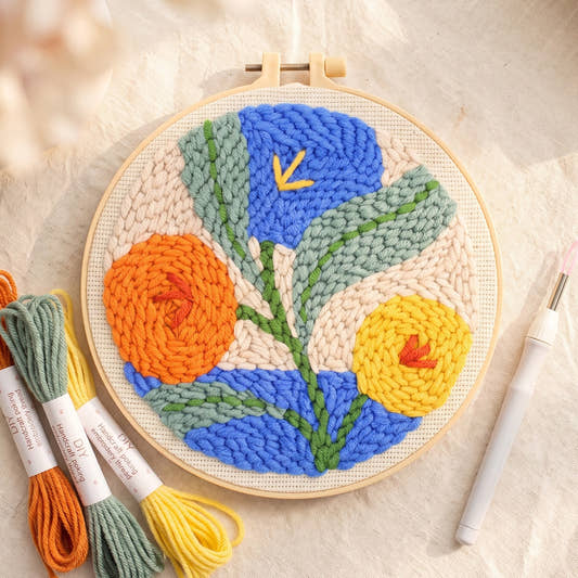 Kit punch needle motif Fleurs oranges, vue de dessus avec des écheveaux (photo d'ambiance)